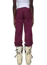 Woman wearing maroon Sp5der Nocturnal Highway Sweatpants with white boots.