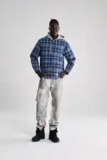 Man wearing Sp5der hooded zip flannel shirt jacket, casual streetwear style.