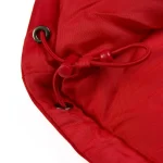 Close-up of red Sp5derworlwide puffer jacket with drawstring detail.