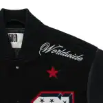 Sp5der Worldwide embroidery close-up on black varsity jacket with red star chenille patch and premium textured stitching
